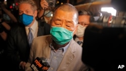 Hong Kong media tycoon and newspaper founder Jimmy Lai, center, walks out from a police station after being bailed out in Hong Kong, Aug. 12, 2020.