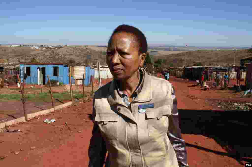 Nkoana trudges up a street in Munsieville, an impoverished township near Krugersdorp. She says after years of public health campaigns too many South Africans still die as a result of HIV. (Photo by Darren Taylor)