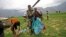 Indian army soldier helps an injured Indian pilgrim after she was rescued from the higher reaches of mountains, at a makeshift helipad at Joshimath, in northern Indian state of Uttarakhand,June 24, 2013.