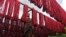 FILE - A woman hangs dyed yarn to dry at a textile mill in India, June 11, 2010.