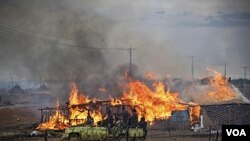 Truk pasukan Sudan utara melewati pusat kota Abyei yang terbakar (28/5).