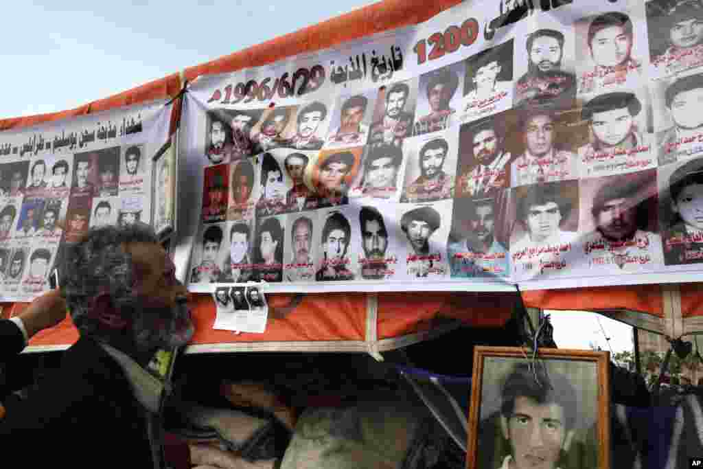 A protester looks at the pictures of protesters who were killed during the last few days during the uprising against Libyan leader Moammar Gadhafi in Benghazi city, February 23, 2011. (Reuters Image)