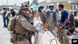 Marinac iz odreda za odgovore u kriznim situacijama (SPMAGTF-CR-CC) pomaže pri evakuaciji na aerodromu Hamid Karzai u Kabulu, Afganistan, 21. avgusta 2021.