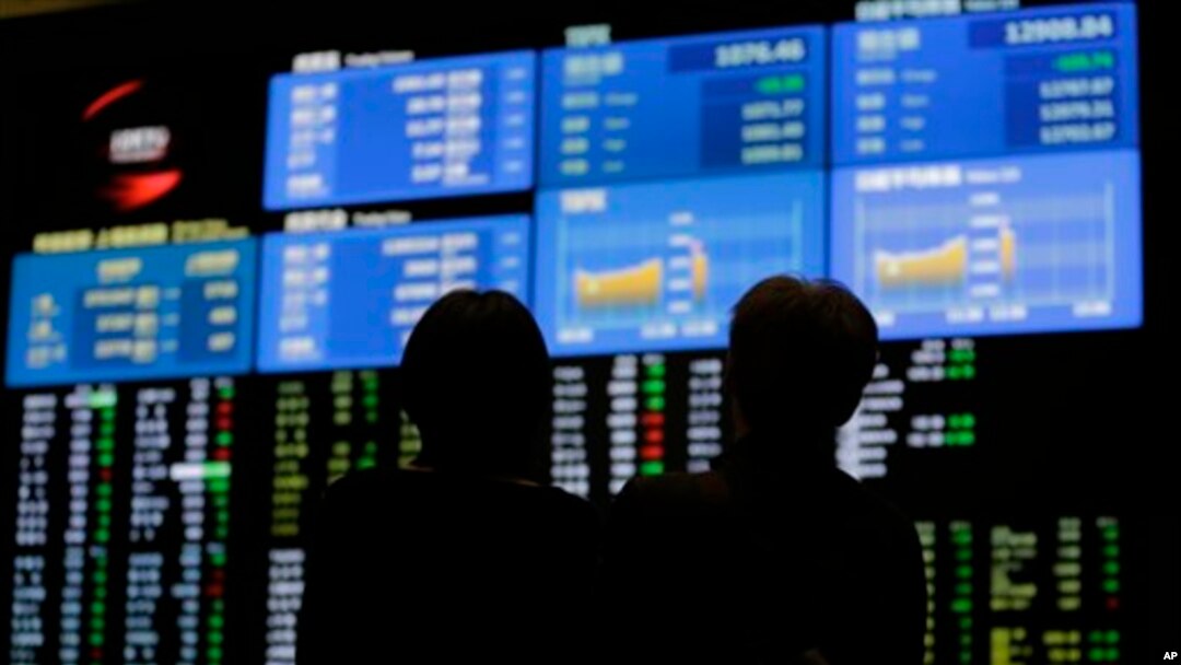 Suasana di depan papan elektronik di Tokyo Stock Exchange, Jepang, 21 Juni 2013 (Foto: dok). Bursa saham Asia kembali jatuh, menyusul melambannya laju pertumbuhan China yang lebih lambat dan pengurangan stimulus moneter oleh Bank Sentral Amerika, Selasa (25/6).
