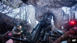 FILE - Ukrainian servicemen of 148th artillery brigade fire by a M777 howitzer towards Russian positions at the frontline on Velyka Novosilka direction, Donetsk region, Ukraine, Jan. 26, 2025.