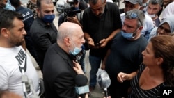 FILE - Amin Sherri, a Lebanese lawmaker of the Hezbollah bloc, center, speaks with families of the victims who were missing from the Aug. 4 explosion that hit the seaport of Beirut, Lebanon, Aug. 6, 2020. 