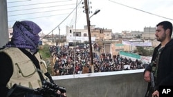 Syrian army defectors secure an anti-Syrian regime protest in the Deir Baghlaba area of Homs province, Jan. 27, 2012.