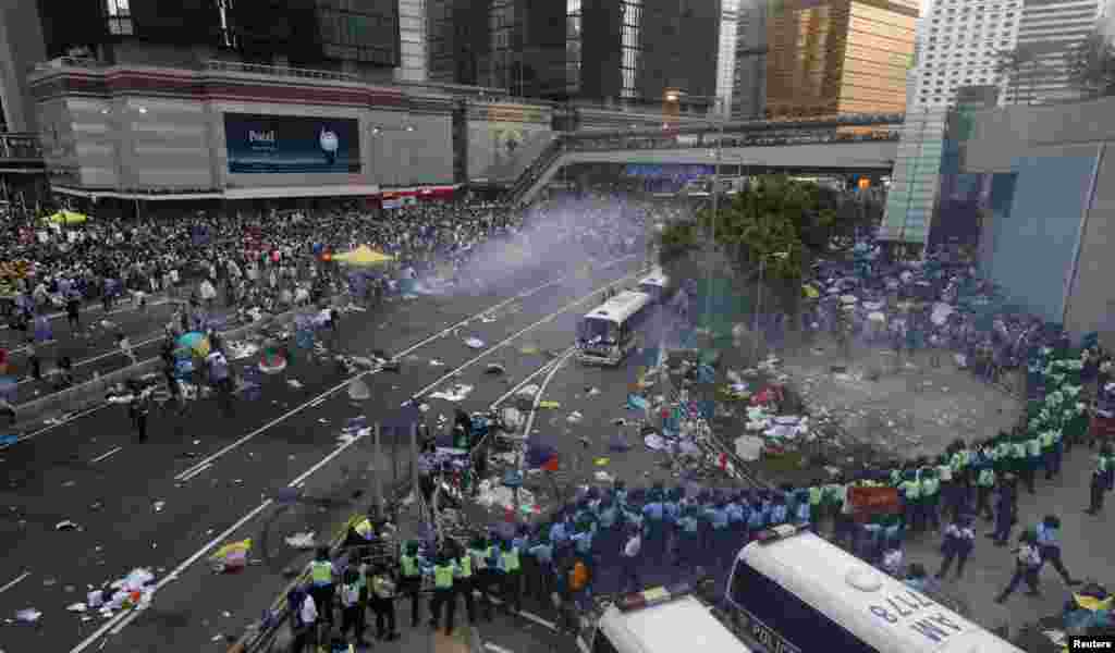 Protesters disperse as riot police fire teargas after thousands of protesters blocked the main street to the financial Central district outside the government headquarters in Hong Kong.