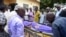 FILE - Relatives and other mourners watch as the body of South Sudanese journalist Peter Julius Moi is taken into the mortuary in Juba, South Sudan, Aug. 20, 2015. 
