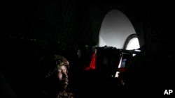 FILE - A member of the Kenya Defense Forces (KDF) looks out of the window of a transport aircraft as it prepares to land, as he and others are deployed as part of the East African Community Regional Force (EACRF), in Goma, in eastern Congo Wednesday, Nov. 16, 2022. 