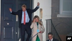 Britain's Prime Minister and Conservative Party leader Boris Johnson leaves Conservative Party headquarters with his partner Carrie Symonds and their dog Dilyn, in London, Dec. 13, 2019.