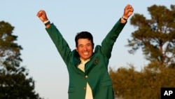 Hideki Matsuyama, of Japan, celebrates wearing the champion's green jacket after winning the Masters golf tournament, in Augusta, Georgia, April 11, 2021. 