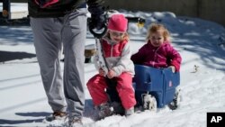 Olivia Crow, center, and sister, Elizabeth, right, are pulled through the snow by their father Craig, Feb. 15, 2021, in San Antonio. San Antonio received 3-5 inches of snow over night.