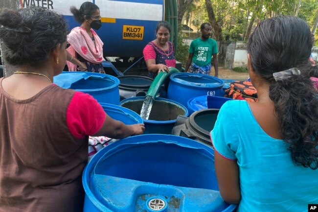 Women wait for their turn to collect water in barrels from a tanker in the Chellanam area of Kochi, Kerala state, India, March 1, 2023. (Uzmi Athar/Press Trust of India via AP)