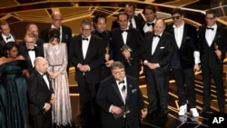 Sutradara Guillermo del Toro, para pemeran dan kru film "The Shape of Water" menerima piala Oscar untuk penghargaan film terbaik, di Dolby Theatre, Los Angeles, 4 Maret 2018. (Foto: Chris Pizzello/Invision/AP)