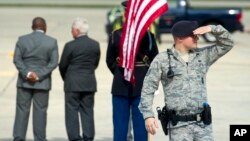 An Air Force Security Forces member guards the flight line as dignitaries await the arrival of Angolan Prime Minister Antonio Paulo Kassoma at Andrews Air Force Base, Md., Aug. 3, 2014.