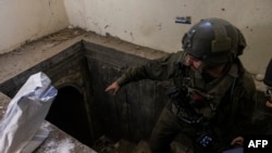 FILE - This picture taken during a media tour organised by the Israeli military on January 8, 2024, shows a soldier standing at the entrance of a tunnel in al-Bureij in the central Gaza Strip.