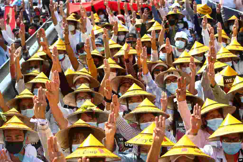 Anti-coup protesters flash the three-fingered salute during a rally near the Mandalay Railway Station in Mandalay, Myanmar, Feb. 22, 2021.