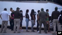 ARCHIVO - Migrantes hacen fila para abordar un autobús después de ser deportados desde el lado estadounidense de regreso a Matamoros, México, el 11 de mayo de 2023. (Foto: AP)