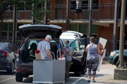 FILE - Students and parents begin to move student's belongings out of Bragaw Hall at North Carolina State University in Raleigh, N.C., Aug. 27, 2020.