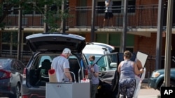 Students and parents begin to move students' belongings out of Bragaw Hall at North Carolina State University in Raleigh, N.C., Aug. 27, 2020, in response to coronavirus clusters on campus.