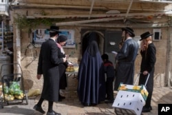 FILE—Ultra-Orthodox Jews collect food distributed to large families for free, in a special market ahead of the upcoming Passover holiday in Jerusalem, April 18, 2024.