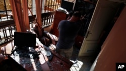 A man stands inside a damaged media office in a stronghold of the Lebanese Hezbollah group, in a southern suburb of Beirut, Lebanon, Sunday, Aug. 25, 2019. 