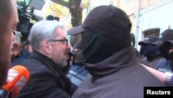 Nika Gvaramia, leader of the Coalition for Change party, is surrounded by police officers before his detention in Tbilisi, Georgia, Dec. 4, 2024, in this image taken from video. (Formula TV via Reuters)