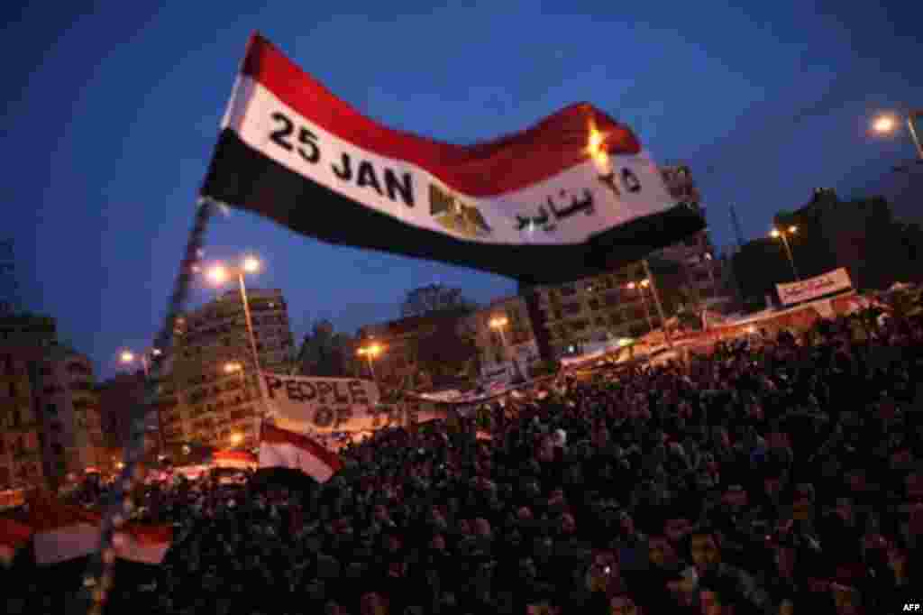 A flag is waved by anti-government protesters as they demonstrate in Tahrir Square in downtown Cairo, Egypt Thursday, Feb. 10, 2011. Thousands of state workers and impoverished Egyptians launched strikes and protests around the country on Thursday over th