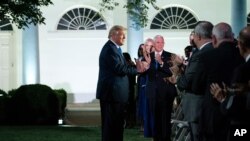 El presidente Donald Trump conversa con algunos de los asistentes al discurso desde la Casa Blanca de la primera dama, Melania Trump, en la segunda jornada de la Convención Nacional Republicana.