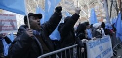 FILE - Uighurs and their supporters protest in front of the Permanent Mission of China to the United Nations in New York, March 15, 2018.