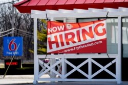 FILE - A hiring sign shows outside of restaurant in Prospect Heights, Illinois, March 21, 2021.