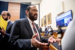 Rep. Al Green, D-Texas, right, speaks to visitors during a break from testimony before a House Financial Services Committee hearing on Facebook's proposed cryptocurrency on Capitol Hill, July 17, 2019.