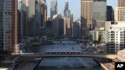 A tram crosses a bridge over a canal that forms the Marina waterfront district of Dubai, United Arab Emirates, April 1, 2015.