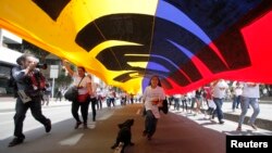 Colombians walk down a central avenue in Bogota during a nationwide march for the country's peace and for victims of war, April 9, 2013.