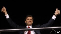 Pedro Passos Coelho, leader of the center-right Social Democratic Party, PSD, gestures to supporters from the top of an open deck bus in Lisbon after his party won Portugal's general elections, June 5 2011