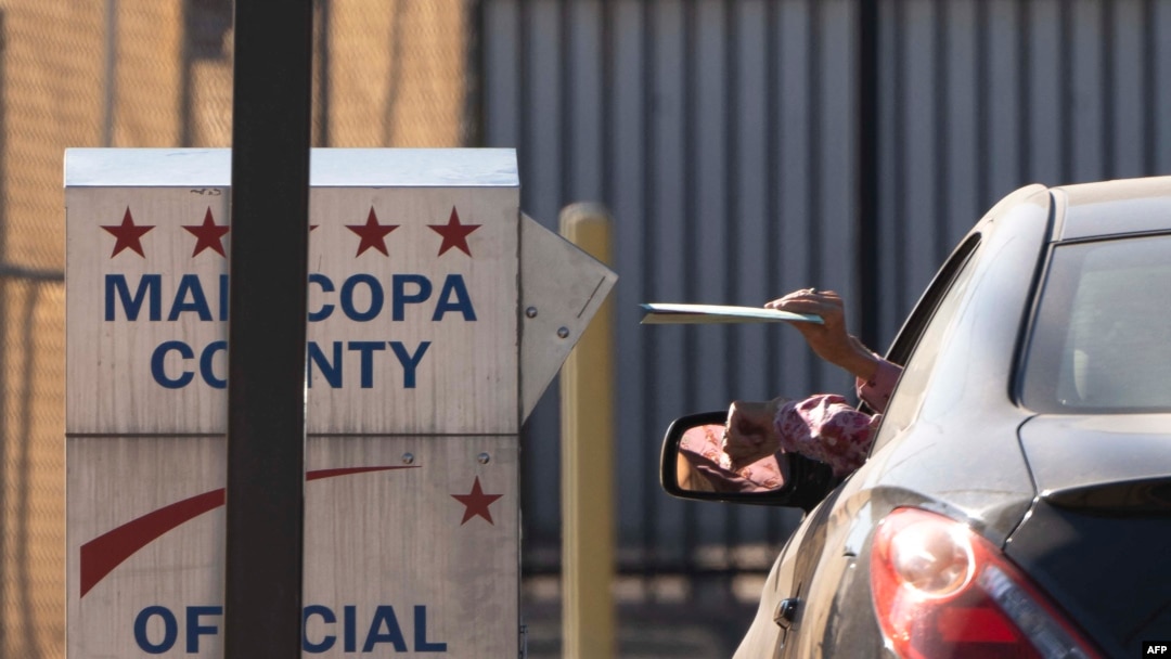 Glasači ubacuju glasačke listiće u kutiju ispred Centra za izbore u okrugu Maricopa u Phoenixu, Arizona, 19. oktobar, 2024.(Foto: AFP/Rebecca Noble)