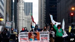 Protesters holding signs navigate along Chicago's South Michigan Avenue during a peaceful protest, April 14, 2021, ahead of the video release of the fatal police shooting of 13-year-old Adam Toledo.