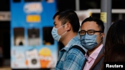 People wear face masks on the street, a day before government scraps the mask rule in Hong Kong, China Feb. 28, 2023. 