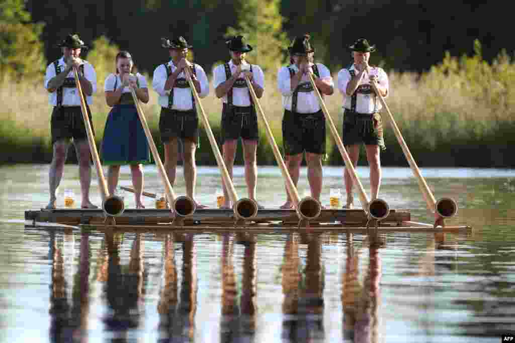 Musicians of the alphorn band &quot;Holdersberger Alp-Traum-Bläser&quot; perform their skills on a raft floating on the Elbsee lake near Aitrang, southern Germany, June 11, 2017.