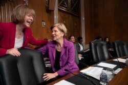 FILE - Sen. Elizabeth Warren, D-Mass., speaks with Sen. Tina Smith, D-Minn., at the start of a Senate hearing with health care companies, on Capitol Hill in Washington, Sept. 18, 2018.