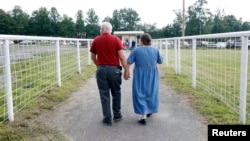 FILE - A couple leaves a free clinic that provides vision, dental and other health services in Wise, Virginia. 