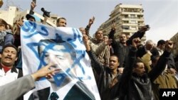 Egyptian protesters shout anti-Mubarak slogans as they flash a poster showing Mubarak framed on the Star of David during a protest in Tahrir square in Cairo, Egypt, Friday, Feb.4, 2011. The Egyptian military guarded thousands of protesters pouring into Ca