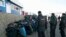Russian police detain migrant workers during a raid at a vegetable warehouse complex in the Biryulyovo district of Moscow October 14, 2013. Over 1,000 migrants were detained across Moscow on Monday in sweeping police raids following Sunday's riots after a