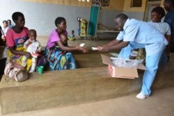 Medical workers distribute nutritious foods to mothers in Zomba district for their children who are at the verge of suffering malnutrition due to the food shortage. (L. Masina/VOA)