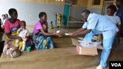 Medical workers distribute nutritious foods to mothers in Zomba district for their children who are at the verge of suffering malnutrition due to the food shortage. (L. Masina/VOA)