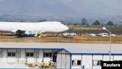Officials inspect a Saudi Air Boeing 747 cargo aircraft after it overran the runway crashing into a tanker truck at the Nnamdi Azikiwe International Airport in Abuja, Dec. 5, 2013.