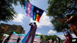 FILE - Demonstrators gather on the steps to the State Capitol to speak against transgender-related legislation bills being considered in the Texas Senate and Texas House in Austin, Texas, May 20, 2021.