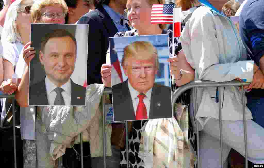 People hold images of Polish President Andrzej Duda and U.S. President Donald Trump during Trump&#39;s public speech at Krasinski Square, in Warsaw, July 6, 2017.