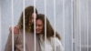 Yekaterina Andreeva and Darya Chultsova, journalists working for the Polish television channel Belsat, embrace inside a defendants' cage during a court hearing in Minsk, Belarus, Feb. 9, 2021.